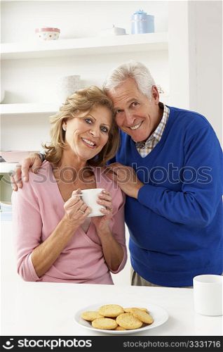 Senior Couple Enjoying Hot Drink In Kitchen