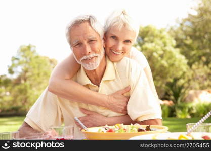 Senior Couple Enjoying Meal In Garden