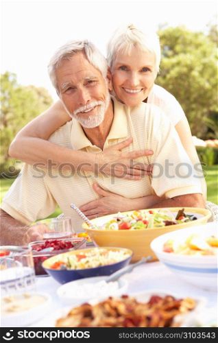 Senior Couple Enjoying Meal In Garden