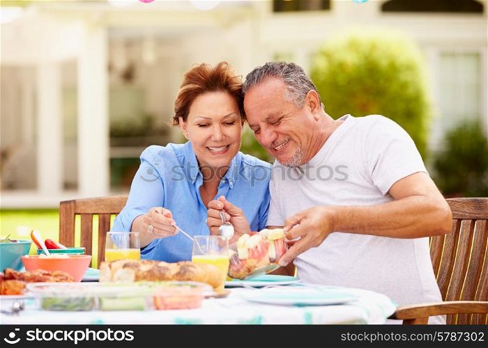 Senior Couple Enjoying Meal In Garden Together