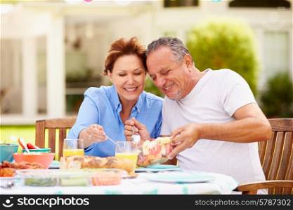 Senior Couple Enjoying Meal In Garden Together