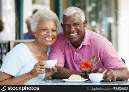 Senior Couple Enjoying Snack At Outdoor Cafe