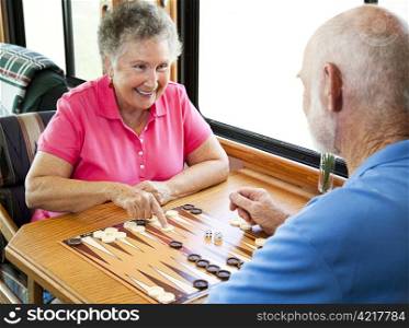 Senior couple enjoys a game of backgammon in their motor home.