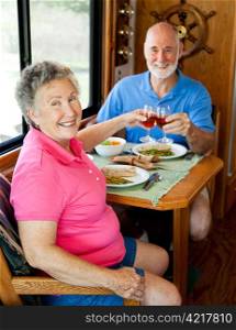 Senior couple enjoys a romantic meal in the kitchen of their motor home.