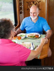 Senior couple enjoys conversation over a healthy meal in their motor home.