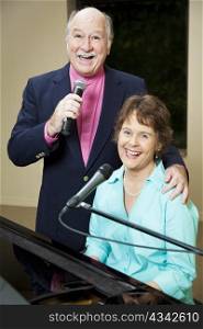 Senior couple enjoys performing vocals and piano together.
