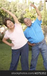 Senior Couple Exercising In Garden