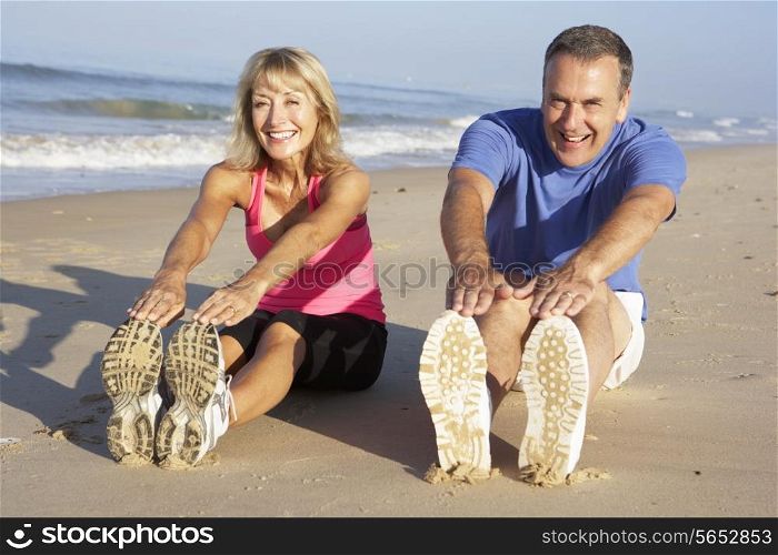Senior Couple Exercising On Beach
