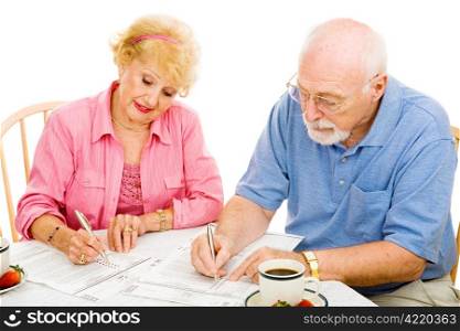 Senior couple filling out absentee ballots at home. Isolated on white.