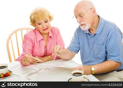 Senior couple filling out their absentee ballots at home. Isolated on white.