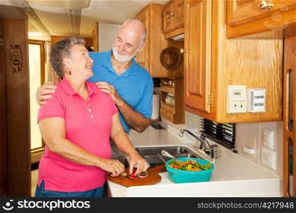 Senior couple get romantic while preparing lunch in their RV.