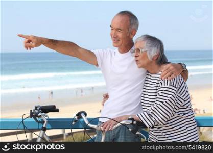 Senior couple having bike ride at the beach