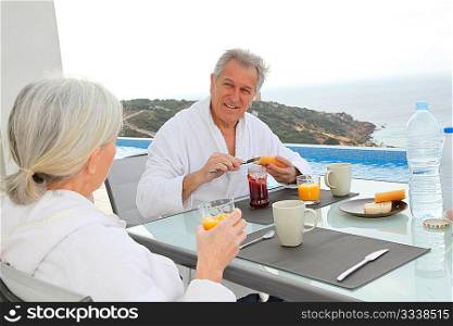 Senior couple having breakfast outside