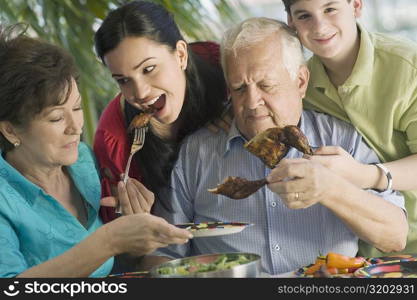 Senior couple having lunch with their grandchildren