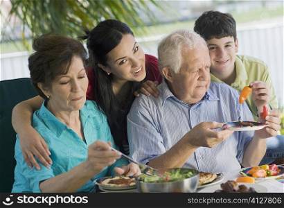 Senior couple having lunch with their grandchildren