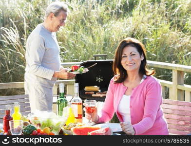 Senior Couple Having Outdoor Barbeque