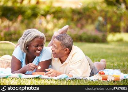 Senior Couple Having Picnic In Garden