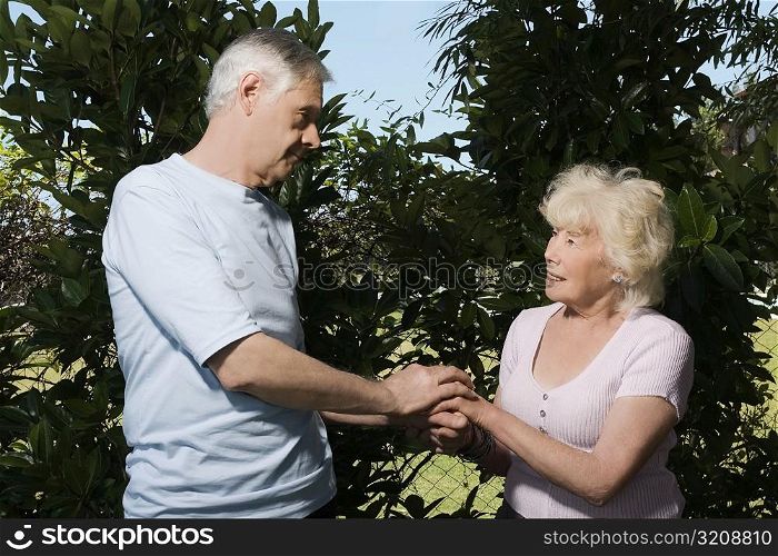 Senior couple holding each other hands in a garden