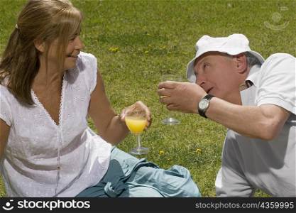 Senior couple holding glasses of juice and smiling