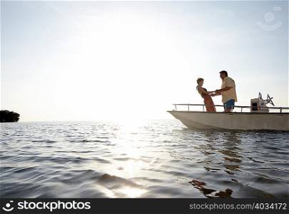 Senior couple holding hands on motorboat