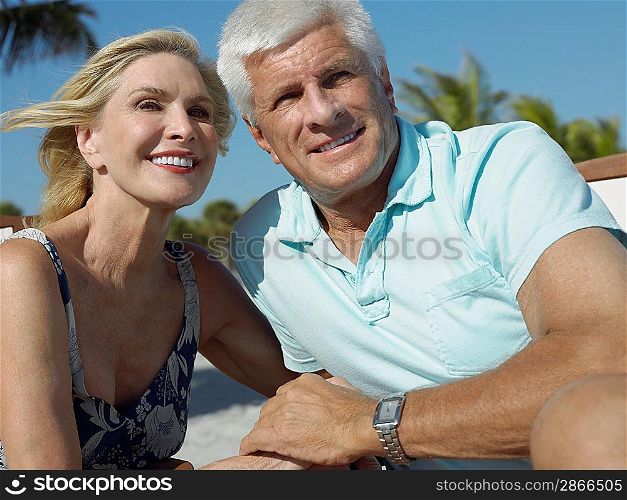 Senior couple holding hands on tropical beach close up