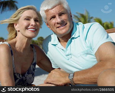 Senior couple holding hands on tropical beach close up