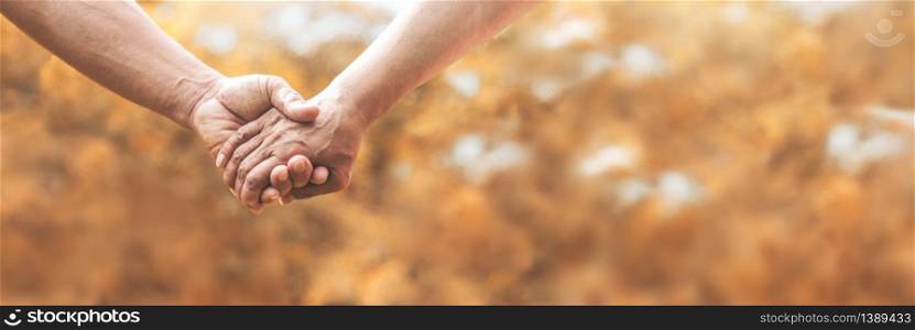 Senior couple holding hands together over nature background in autumn. Lover, valentine?s day concept. Banner.