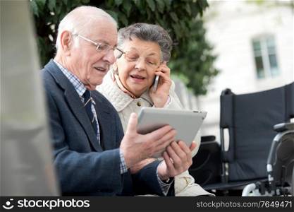 senior couple holding tablet and giving a call