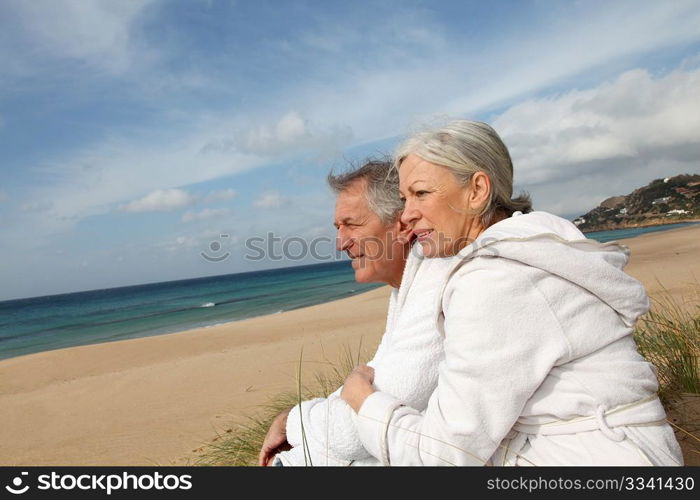 Senior couple in bathrobe at the beach