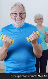 Senior Couple In Fitness Class Using Weights