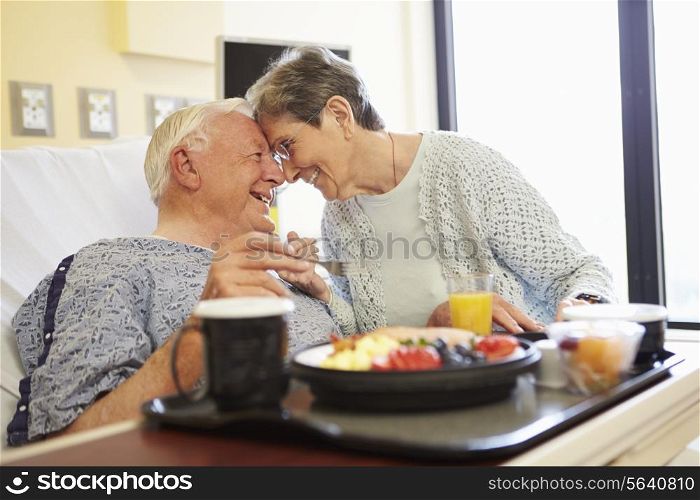 Senior Couple In Hospital Room As Male Patient Has Lunch
