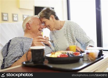 Senior Couple In Hospital Room As Male Patient Has Lunch