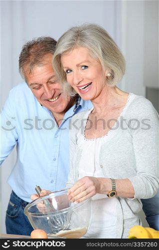 Senior couple in kitchen baking cake