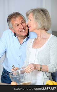 Senior couple in kitchen baking cake