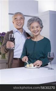 Senior Couple in Kitchen Drinking Wine and Cheese