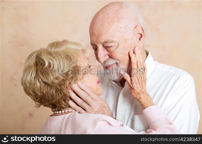 Senior couple in love, looking deeply into each other&rsquo;s eyes.
