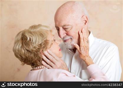 Senior couple in love, looking deeply into each other&rsquo;s eyes.
