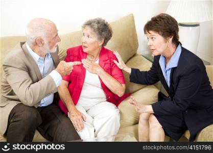 Senior couple in marriage counseling argues in front of their therapist.
