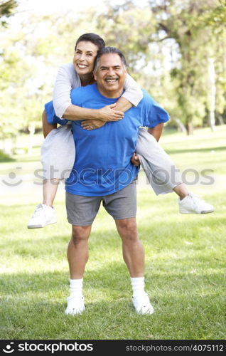 Senior Couple In Sports Clothing Having Fun In Park