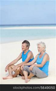 Senior Couple In Sports Clothing Relaxing On Beautiful Beach