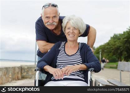 senior couple in wheelchair enjoying the sea