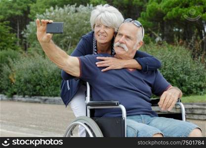 senior couple in wheelchairs doing a selfie