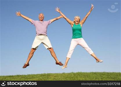 Senior couple jumping in air