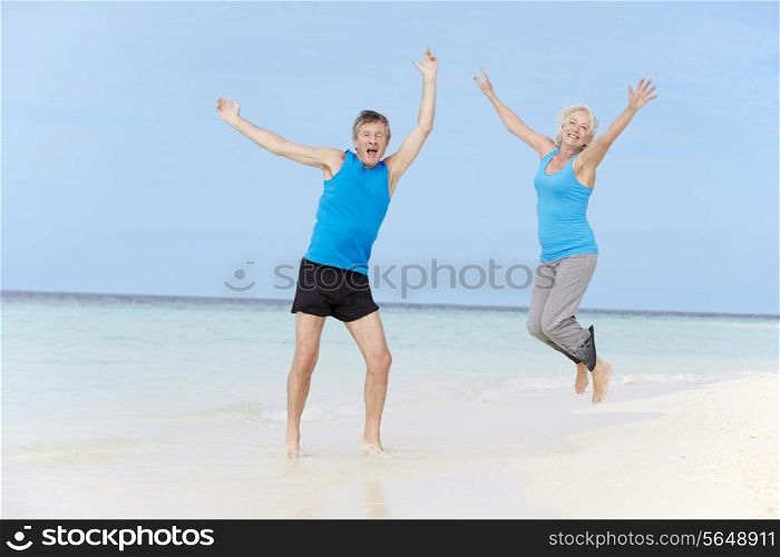Senior Couple Jumping On Beautiful Beach