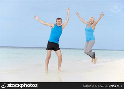 Senior Couple Jumping On Beautiful Beach