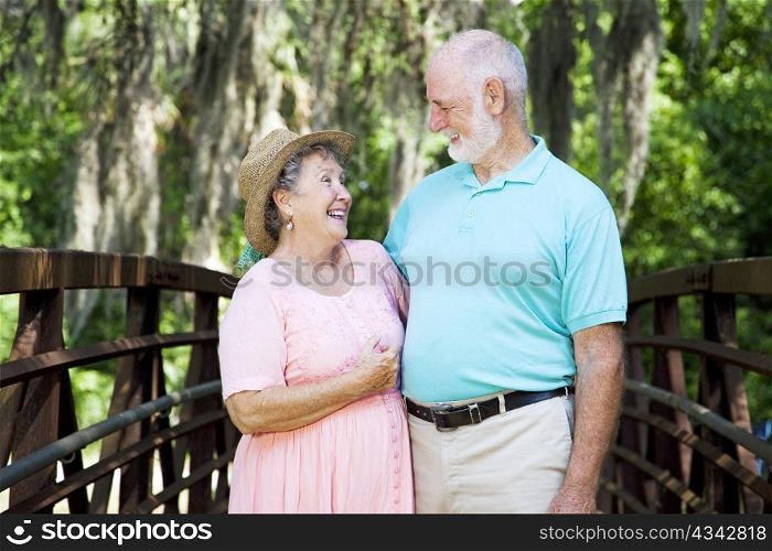 Senior couple laughing together in a beautiful natural setting.
