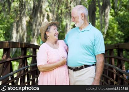 Senior couple laughing together in a beautiful natural setting.