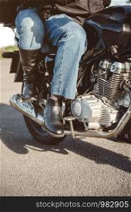 Senior couple legs with boots sitting over motorcycle ready to go. Couple sitting over motorcycle ready to go