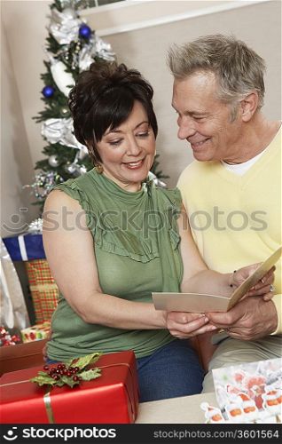 Senior couple looking at card over Christmas presents