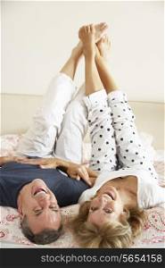 Senior Couple Lying Upside Down Together In Bed
